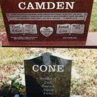 A red granite monument for the Camden family sits above a smaller black granite gravestone for a member of the Cone family.