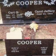 A dark granite tombstone for Carl and Carol Cooper, listing their birth and death dates and the names of their children.