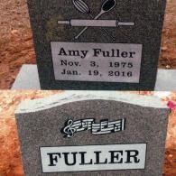 Two gray stone monuments; one features baking utensils, the other musical notes above the name 