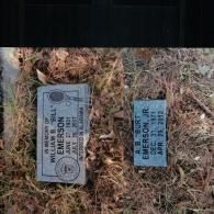 Two gray granite memorial markers set in the ground, each inscribed with names and birth and death dates.