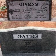 Two upright grey stone headstones in a cemetery; the top one is for the Givens family, the bottom for the Gates family.