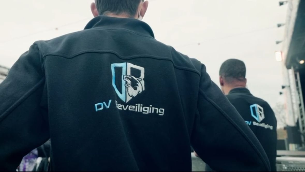 Een beveiliger houdt een portofoon vast in een kantoor.