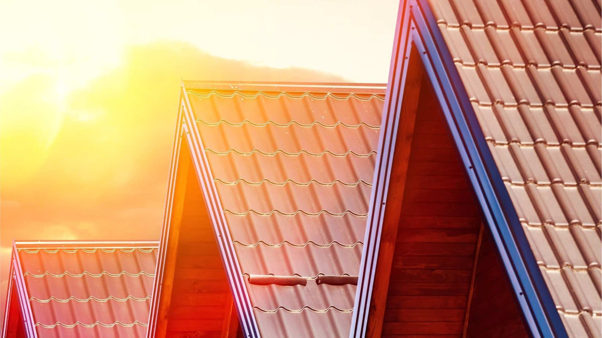 A person is installing shingles on a roof with a hammer.