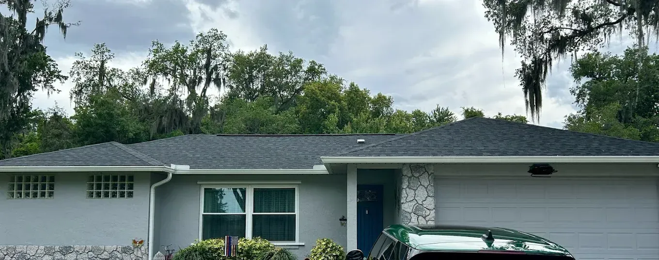 Two flags are flying in front of a house