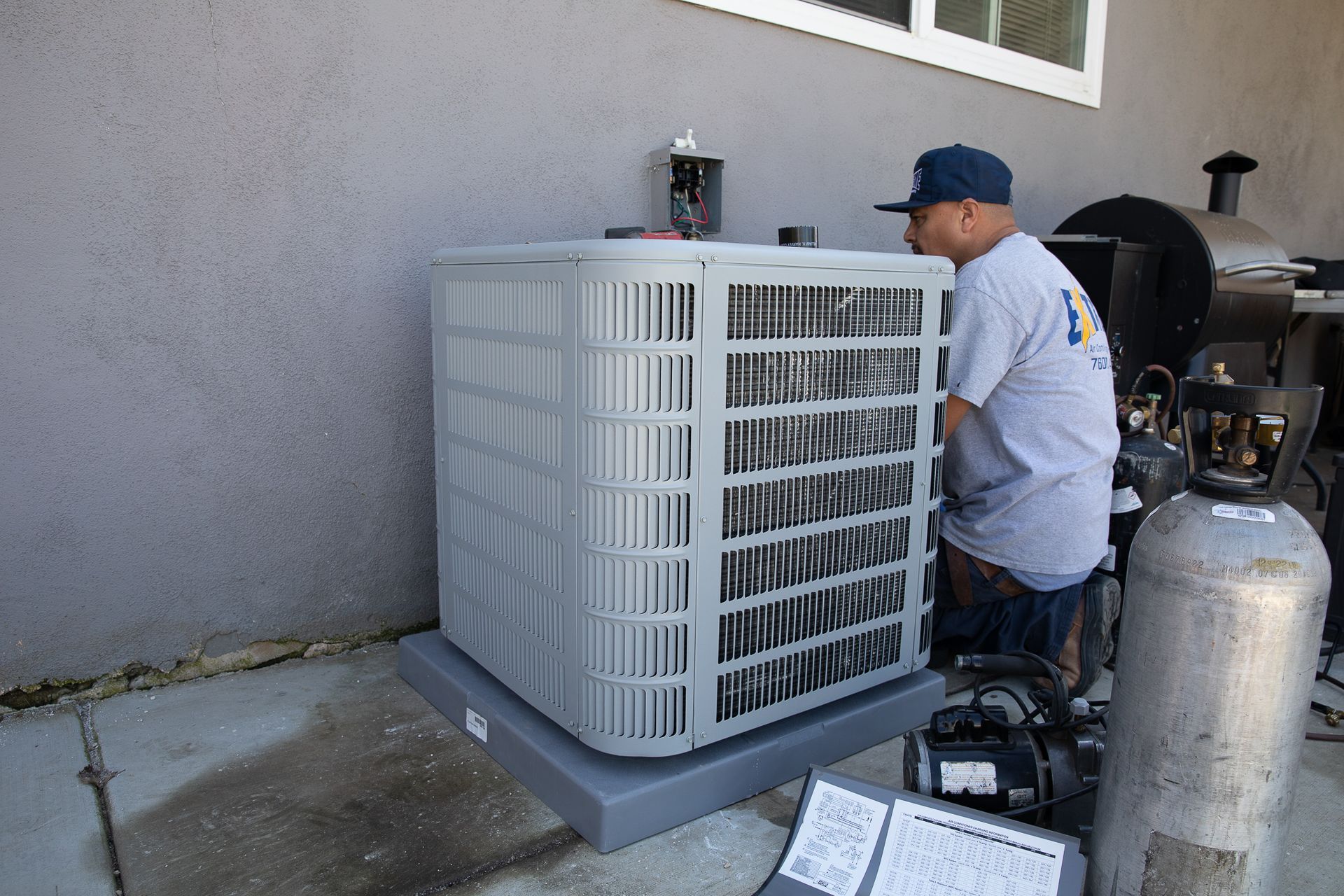 A man working on an air conditioner with the number 13 on his shirt