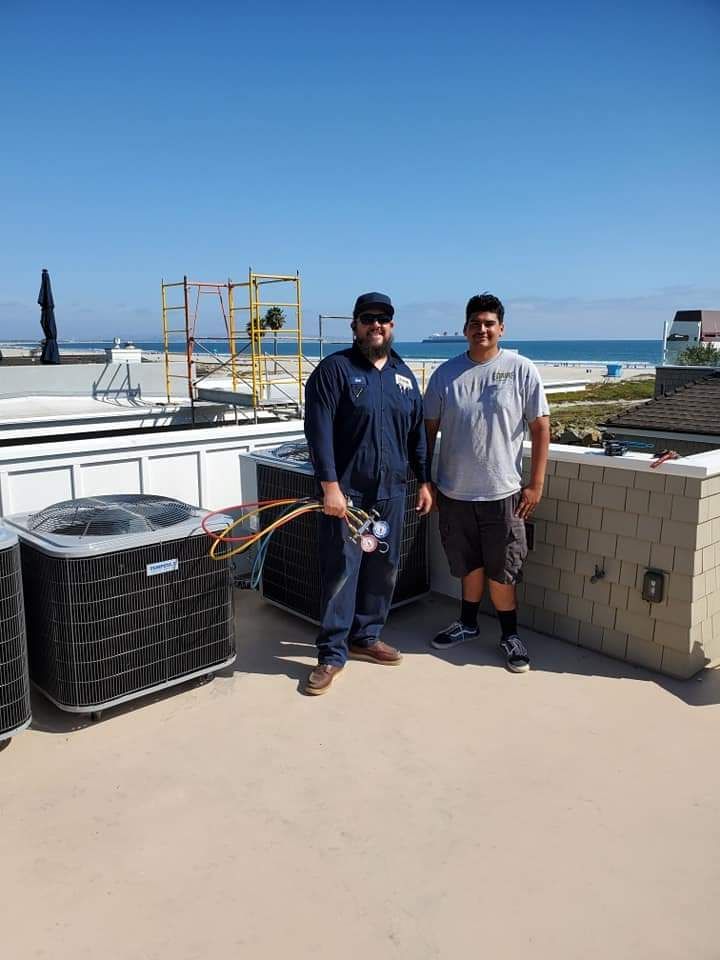 Two men standing next to each other on a roof