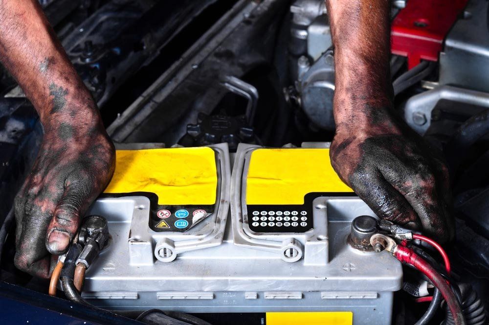 Mechanic Holding Car Battery — Automotive Batteries in Boonah, QLD