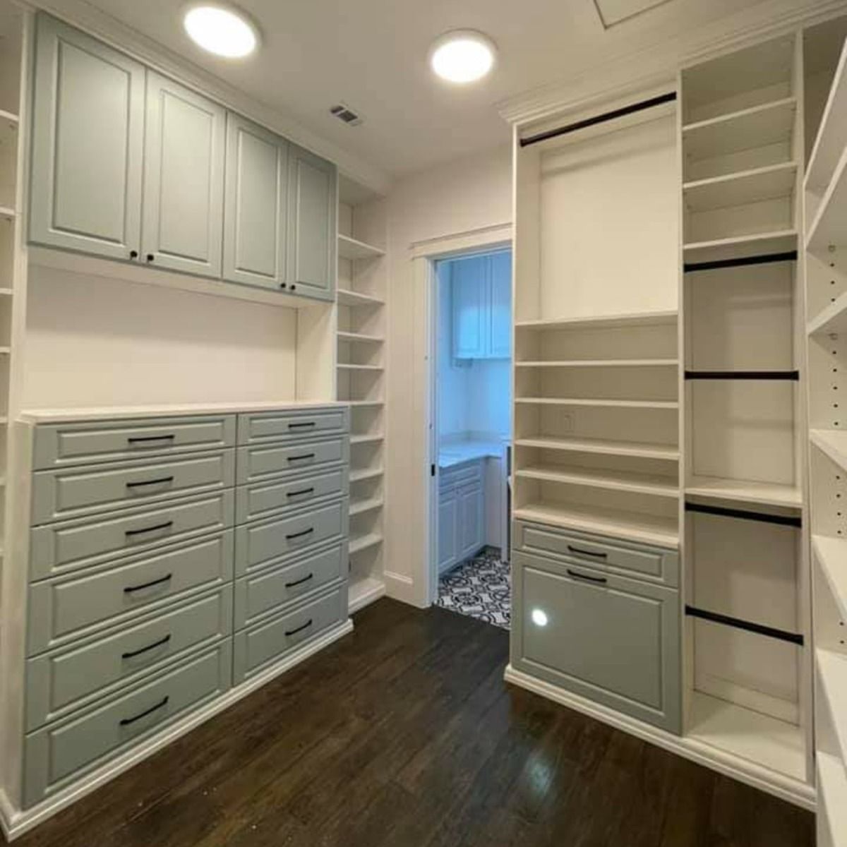 Walk-in closet with custom built-ins. Features include drawers, shelves, and hanging rods, painted in white and blue-gray.