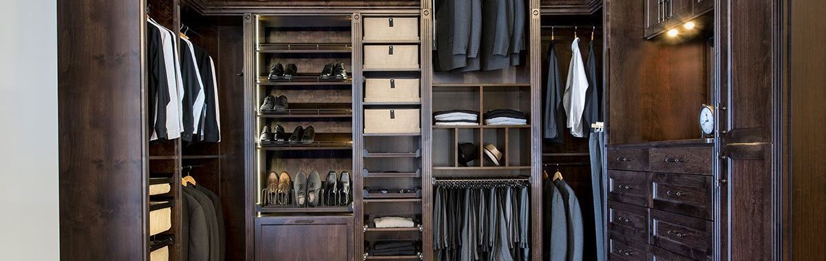 A walk in closet filled with lots of clothes and drawers.