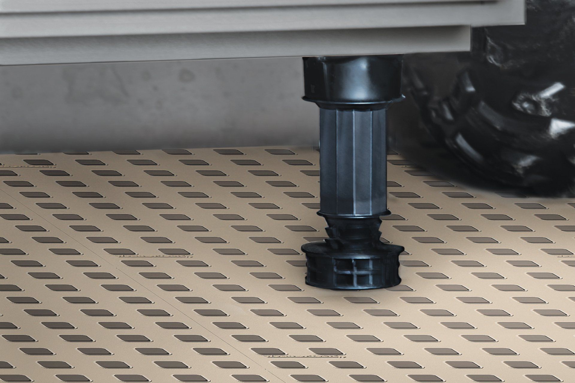 A black plastic leg is sitting on a tiled floor