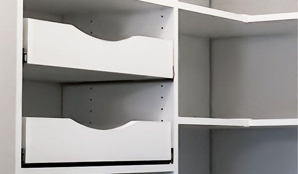A close up of a closet with two drawers and shelves.