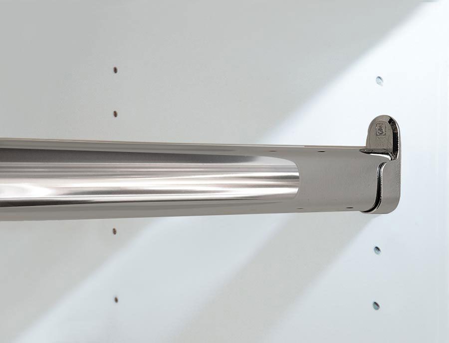 A close up of a stainless steel clothes rack on a white wall.