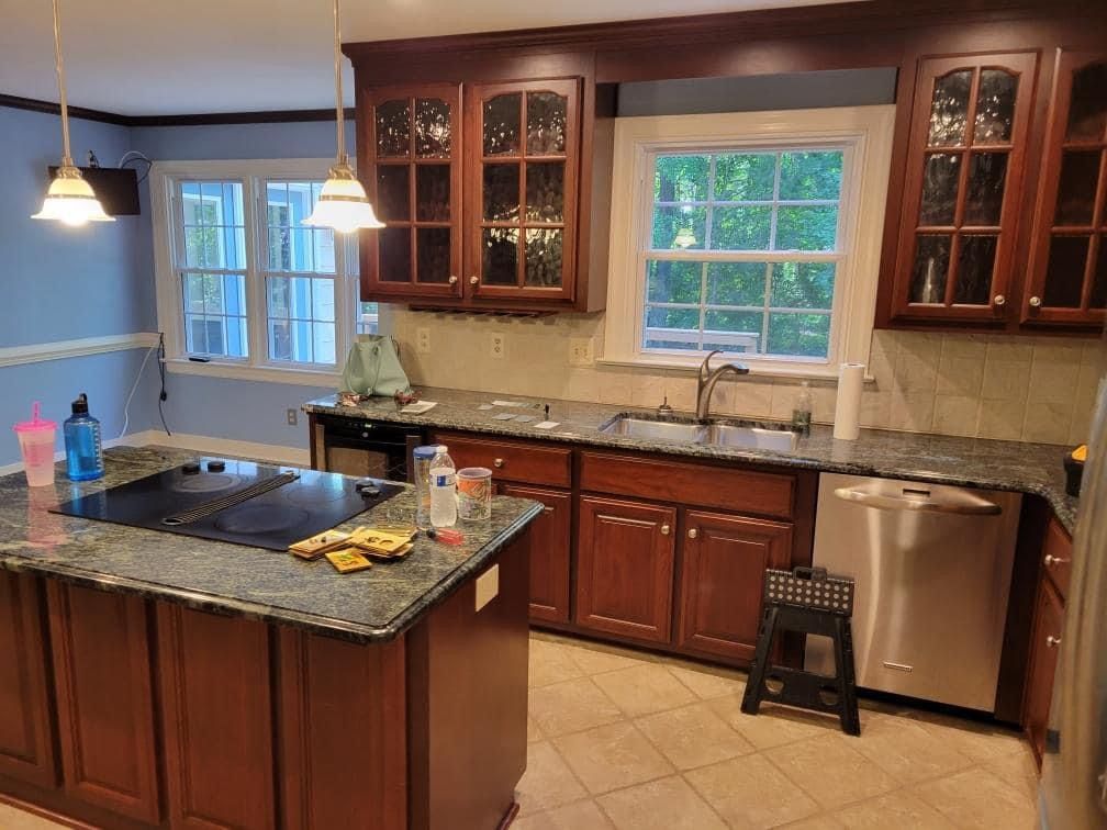 a kitchen with wooden cabinets , granite counter tops , stainless steel appliances and a large island .
