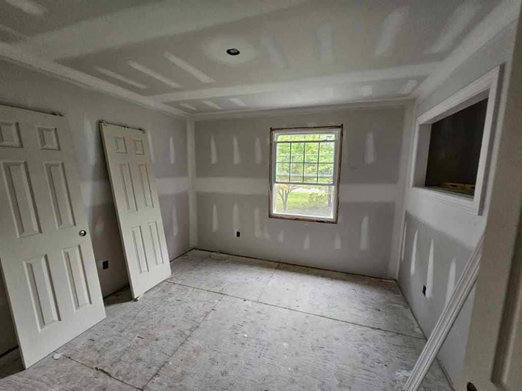 A room with drywall on the walls and a window.