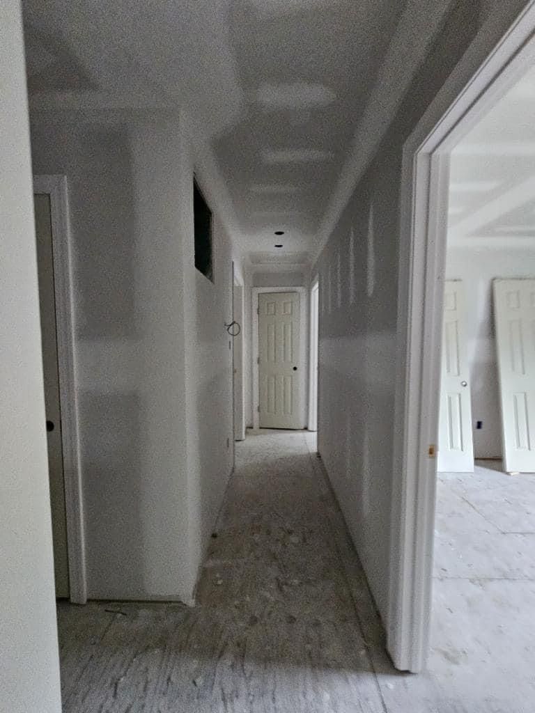 A long hallway in a house that is being remodeled.