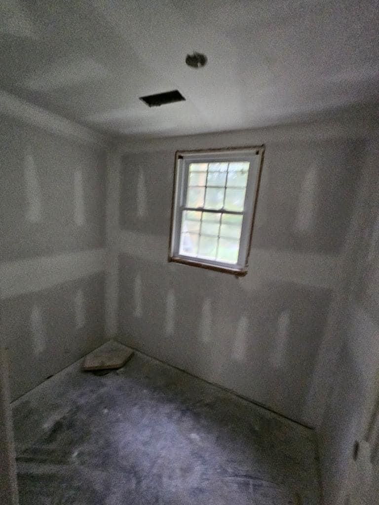 A room with drywall and a window in it