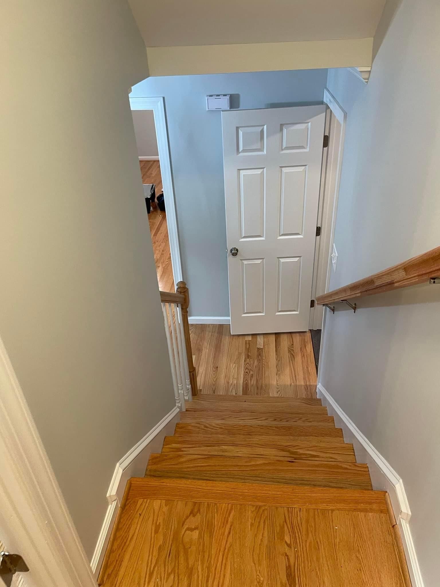 A wooden staircase leading up to a door in a house.