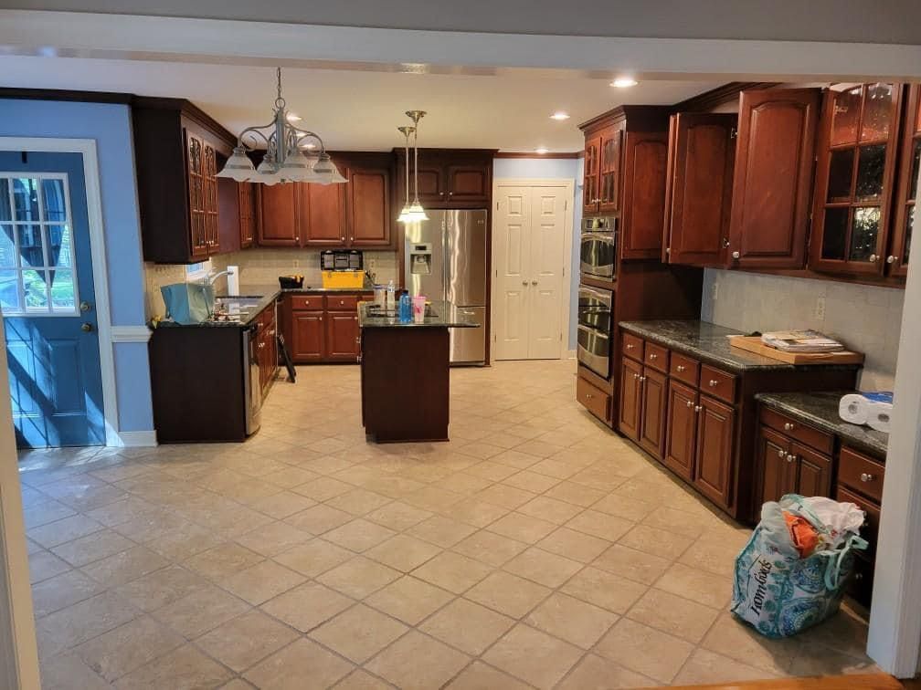 a kitchen with wooden cabinets and a tiled floor