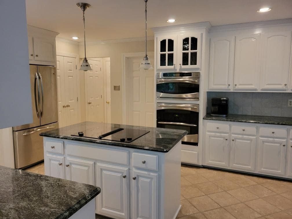 a kitchen with white cabinets and stainless steel appliances