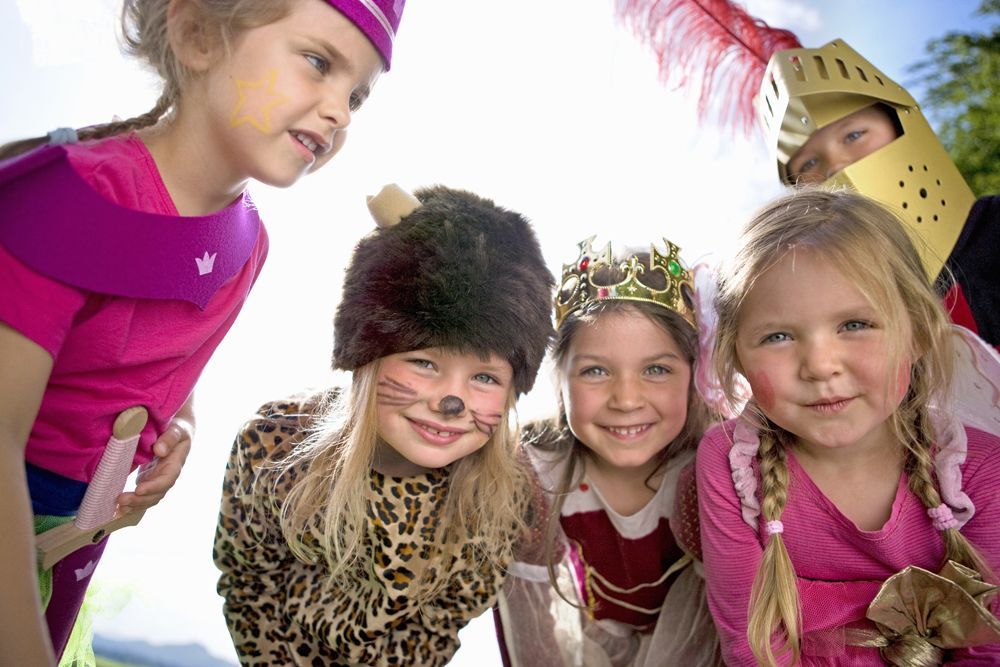 A group of young girls dressed in costumes are posing for a picture.