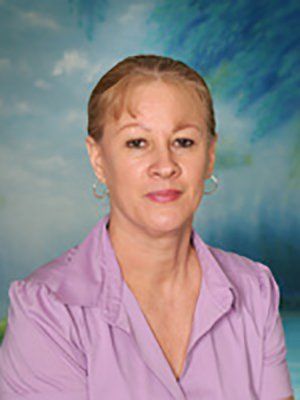 A woman in a purple shirt is posing for a picture.