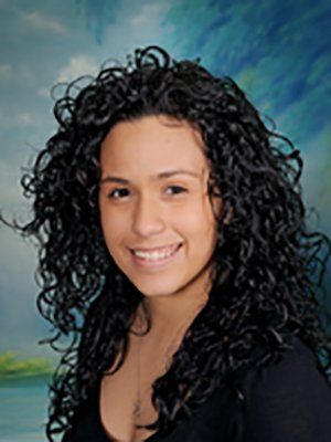 A woman with curly hair is smiling for the camera