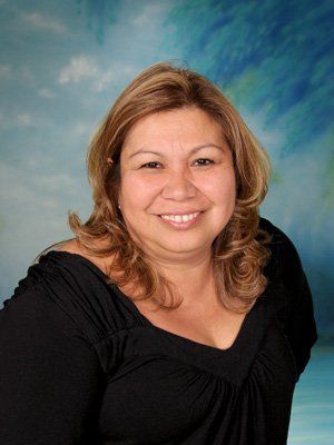 A woman in a black shirt is smiling for the camera.