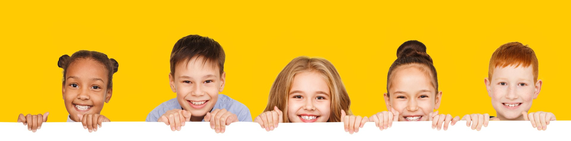 Happy children with empty board for your text isolated over yellow background, copy space