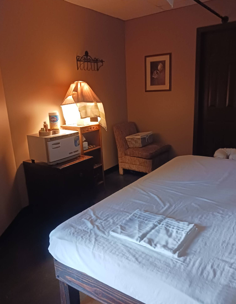 A hotel room with a bed a chair and a microwave