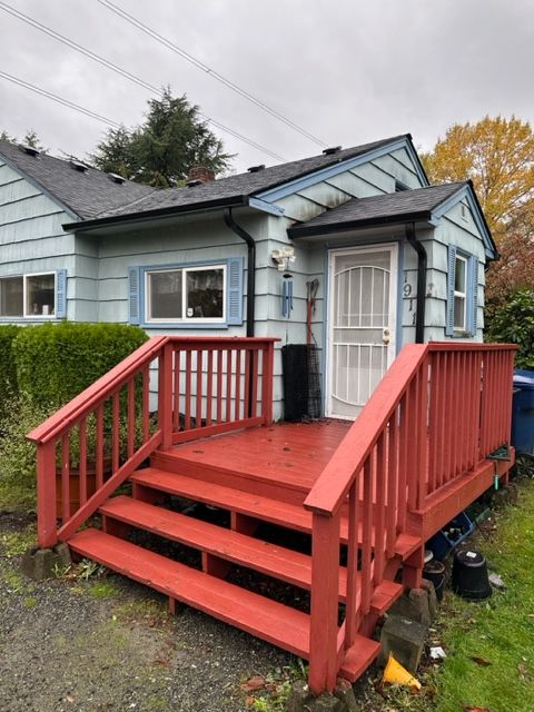 A blue house with a red deck and stairs