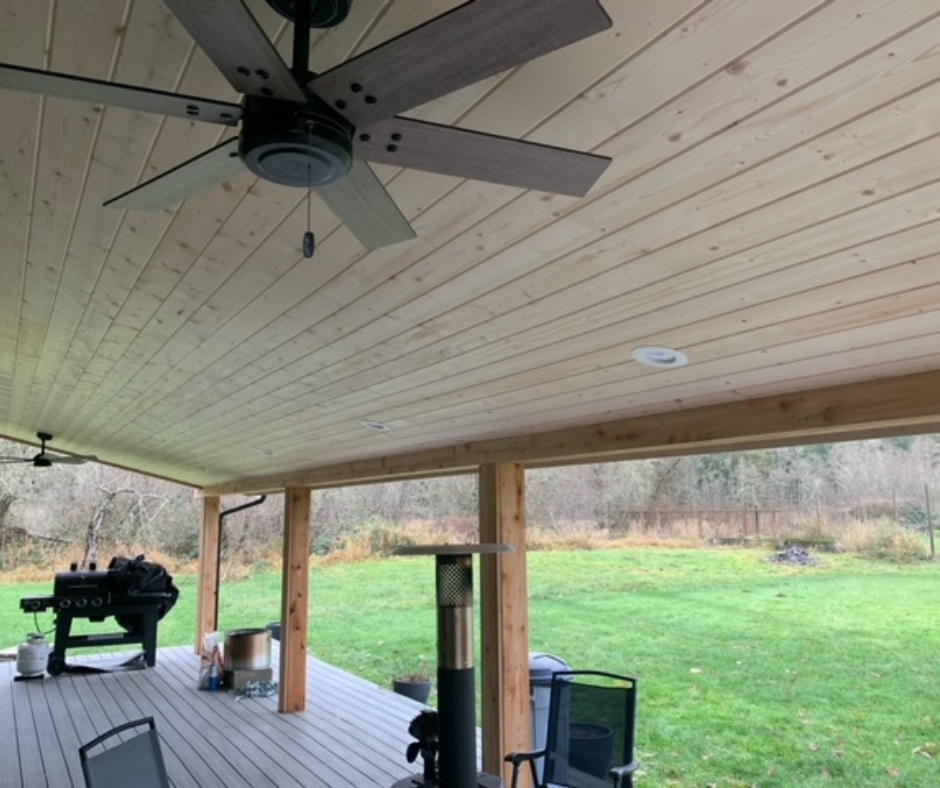 A ceiling fan is hanging from the ceiling of a porch.