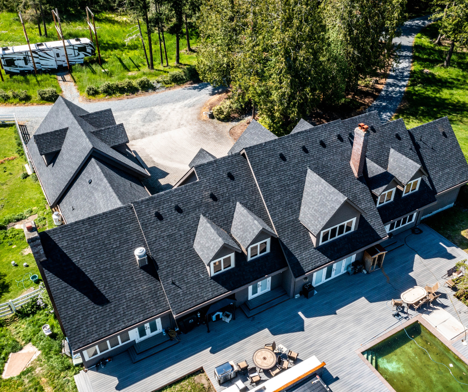 An aerial view of a large house with a black roof