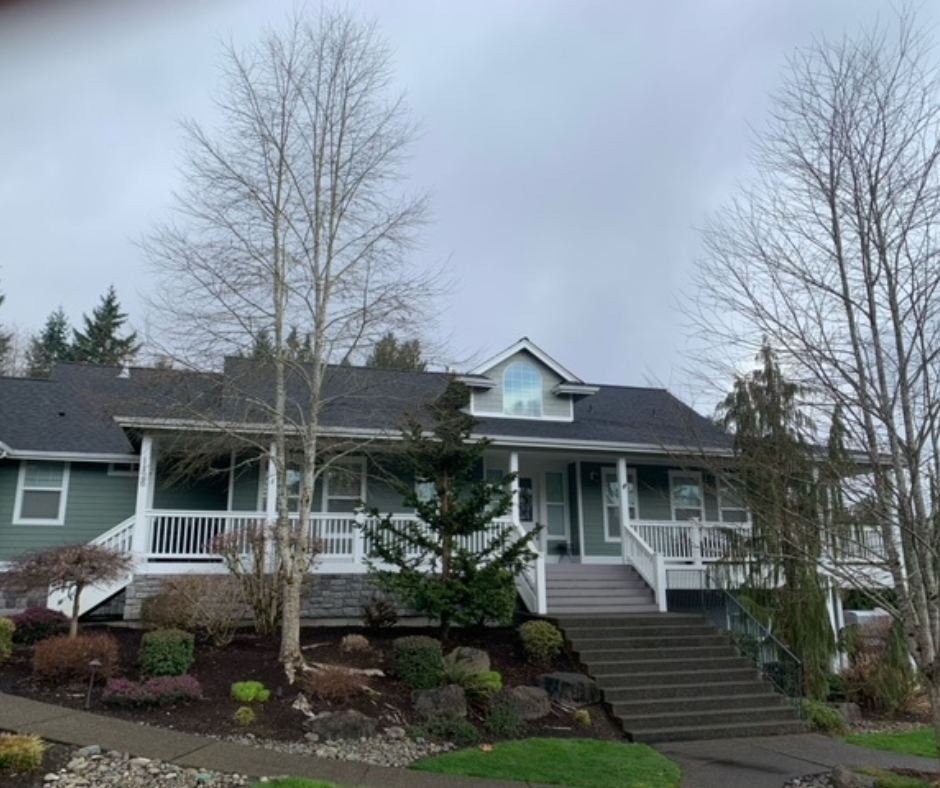 A green and white house with a black roof