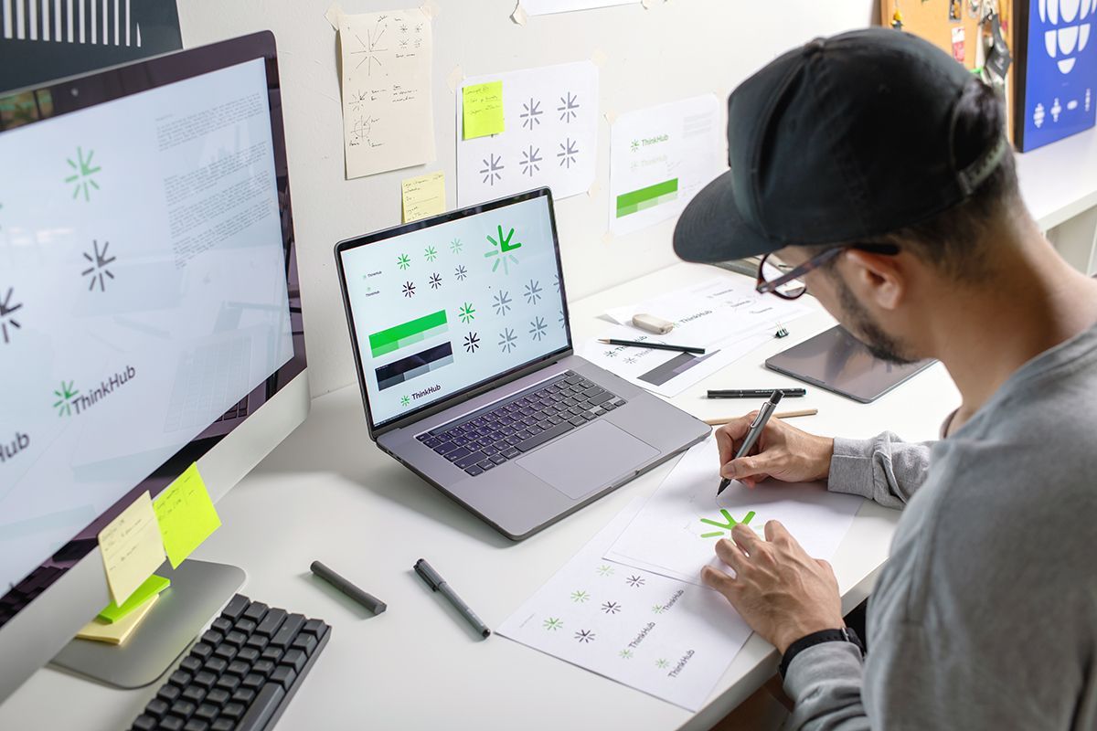 Graphic designer sitting a work desk creating logo