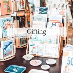 Greeting cards and small dishes on display, labeled 