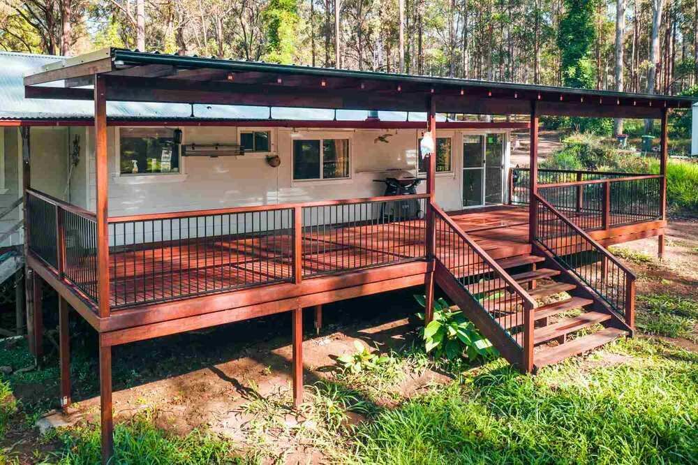 A House With A Large Deck And Stairs In The Woods — Sedah Home Improvements In Port Macquarie, NSW