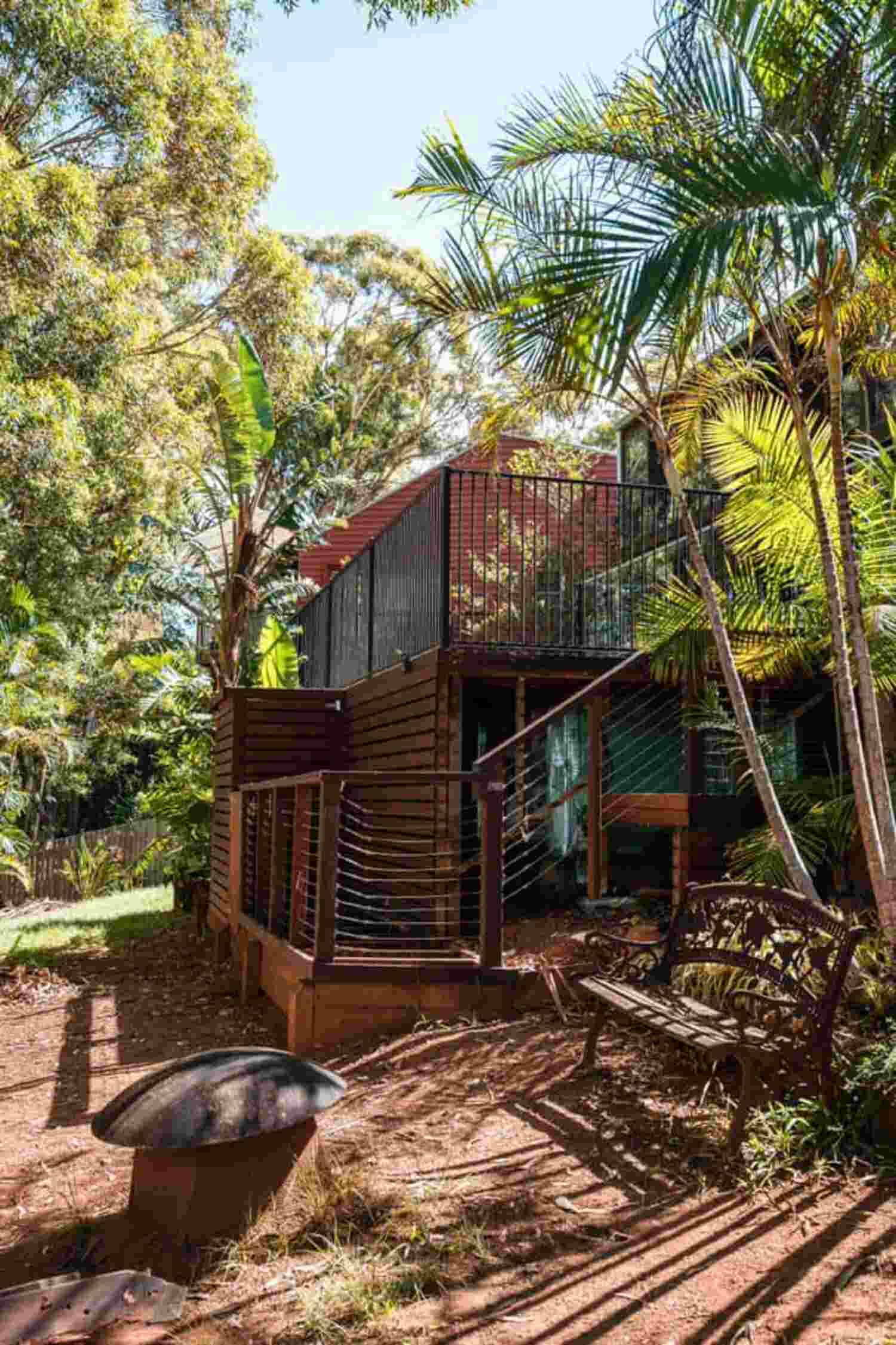 A Small House With Stairs Leading Up To It Is Surrounded By Trees — Sedah Home Improvements In Port Macquarie, NSW