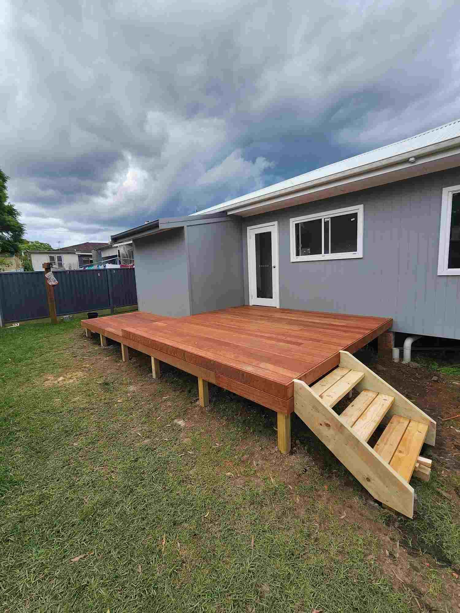 A House With A Wooden Deck And Stairs In Front Of It — Sedah Home Improvements In Port Macquarie, NSW