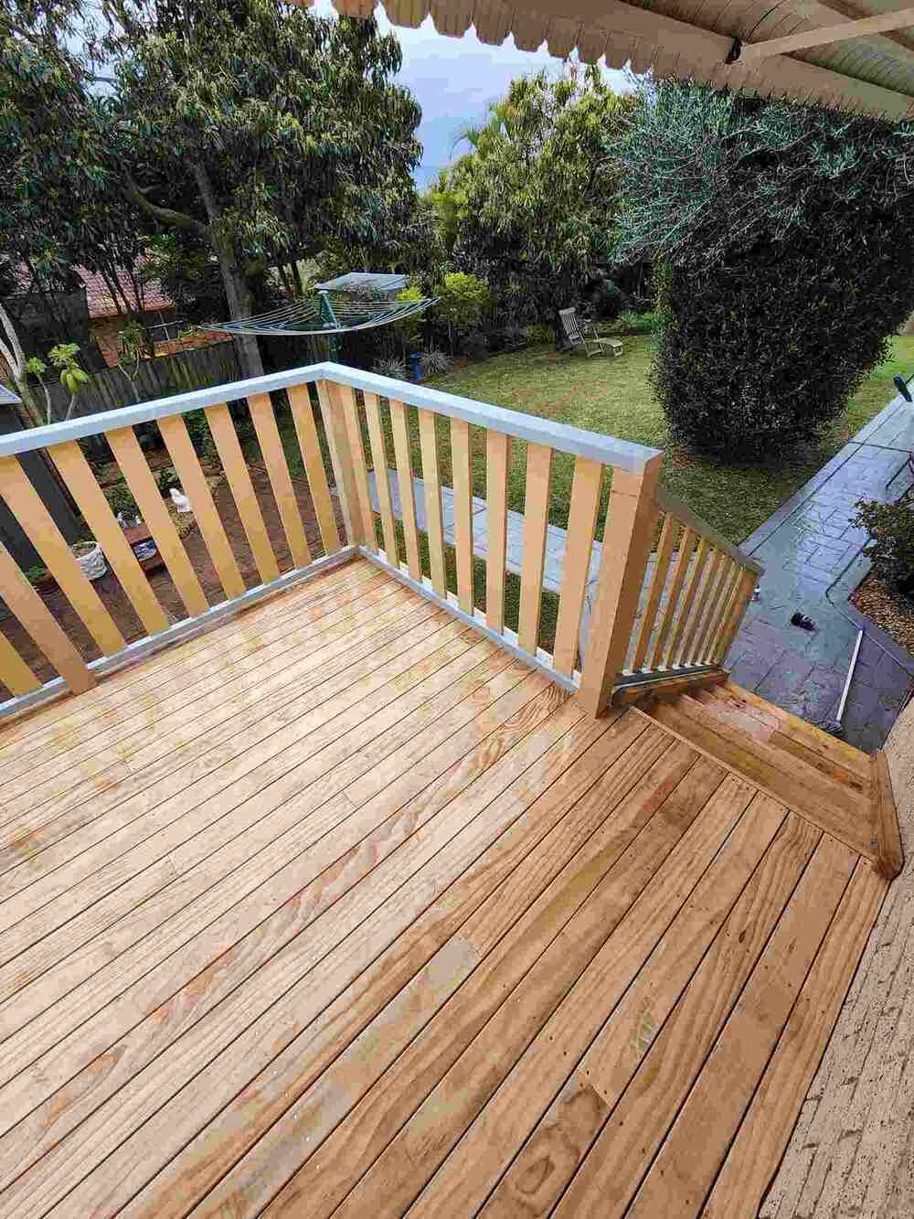 A Wooden Deck With A Metal Railing And Stairs Leading Up To It — Sedah Home Improvements In Port Macquarie, NSW