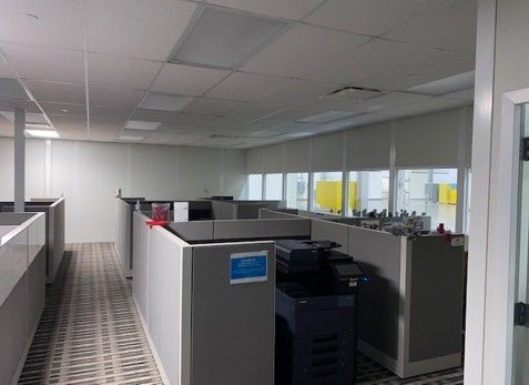 Empty office cubicles with a printer, neutral colors.