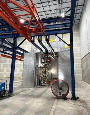 Industrial setting with metal structure, equipment, and large fan.