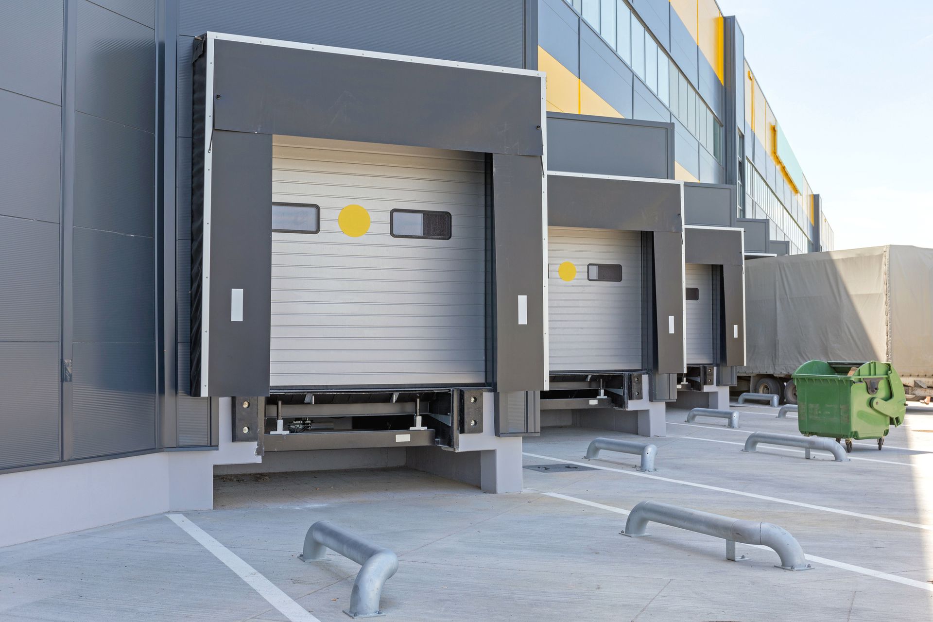 Loading docks with closed silver doors on a modern warehouse building.