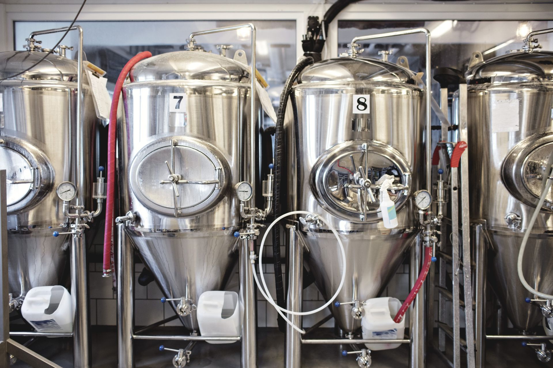 Stainless steel brewing tanks inside a brewery.