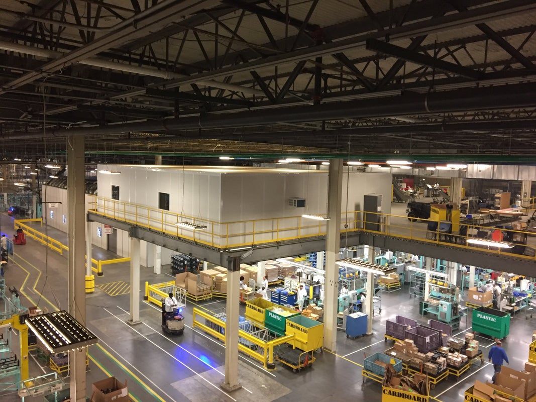 Warehouse interior with orange stairwell and elevated shelving units.