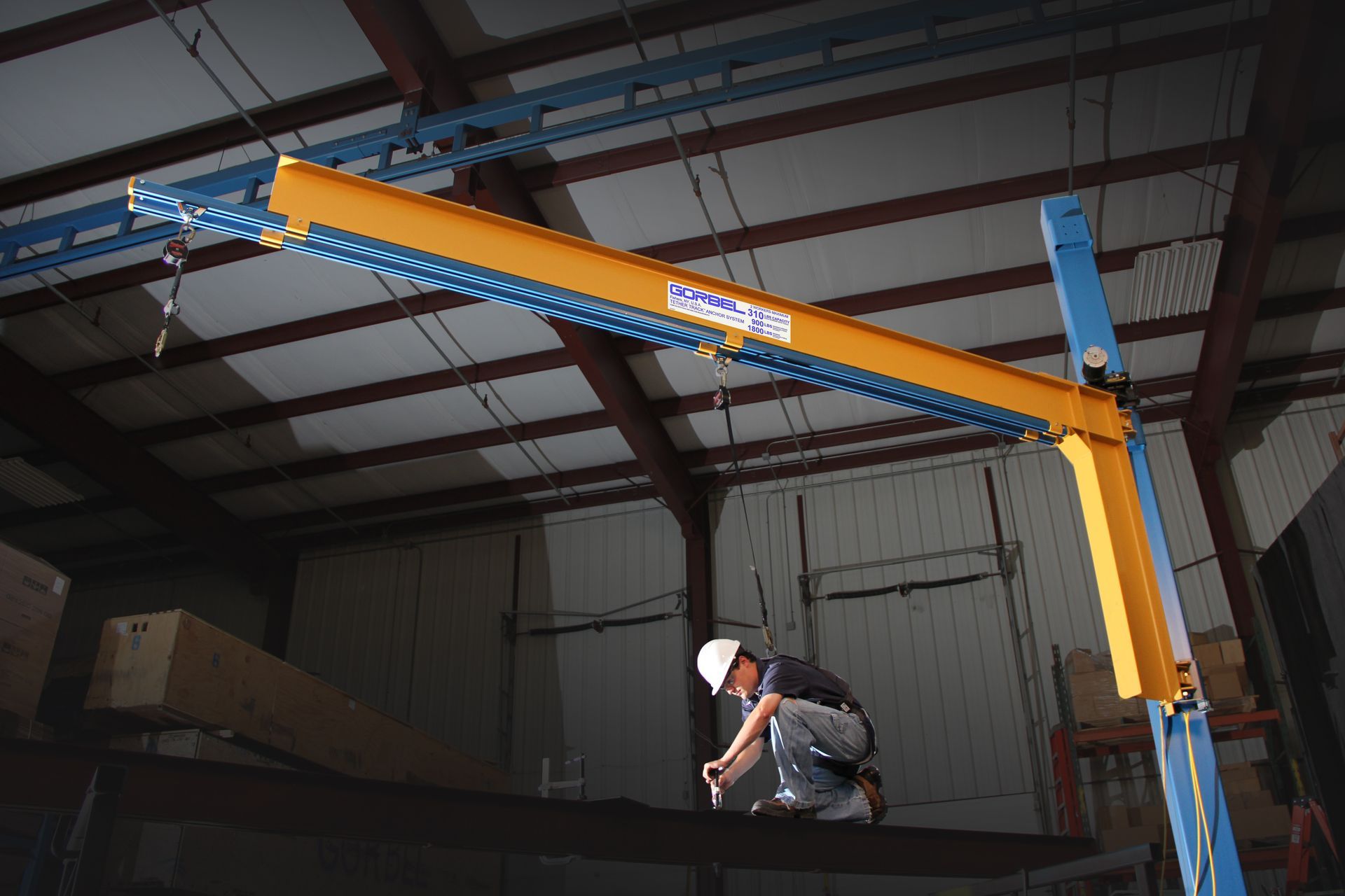 Metal platform suspended from ceiling beams in a factory, with visible framework and equipment.