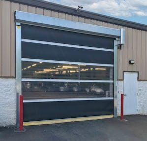 Metal platform suspended from ceiling beams in a factory, with visible framework and equipment.