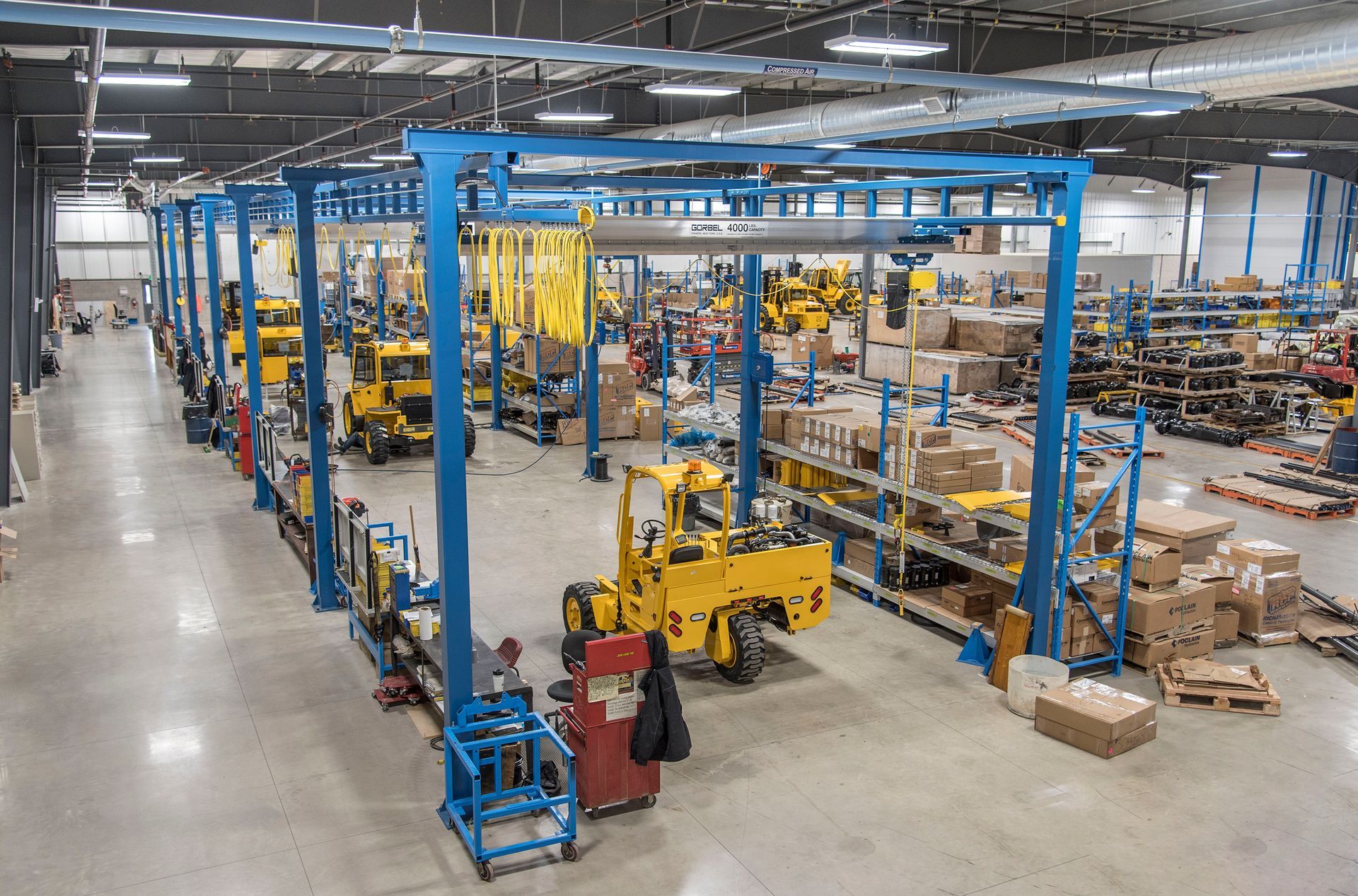 Yellow overhead crane system inside a large industrial warehouse. Yellow overhead crane system inside a large industrial warehouse.