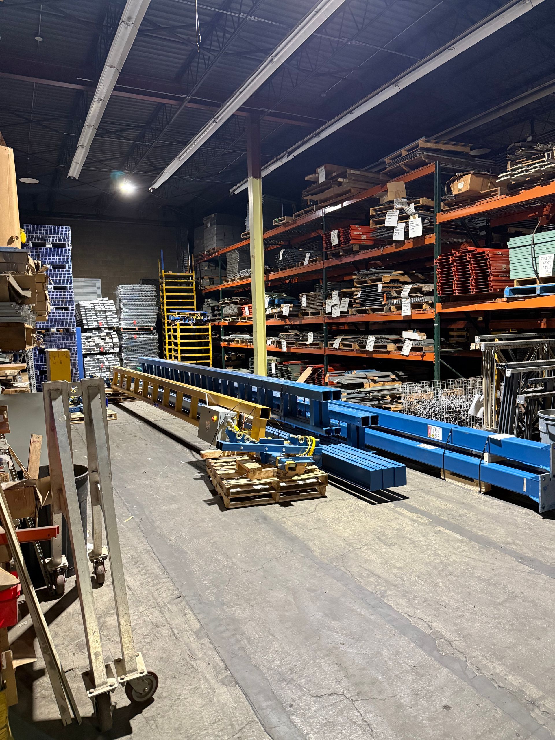 Warehouse worker pushing boxes on a cart in a storage facility.