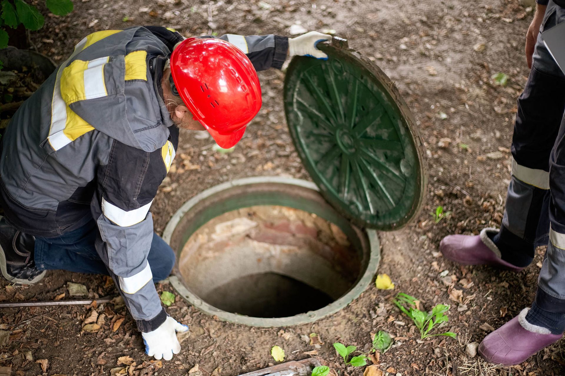A man is inspecting a septic tank.