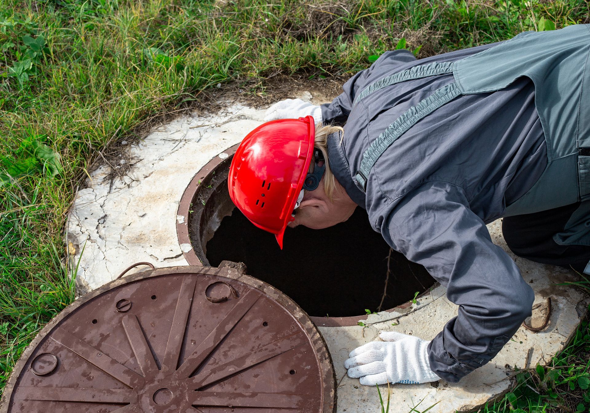 A man is inspecting a septic tank.